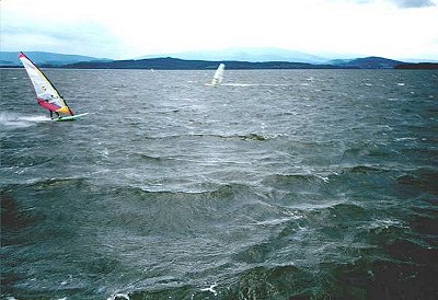 Windsurfing na Lipně, Černá v Pošumaví, fouká JZ vítr o síle přibližně 10 m/s, v popředí jede Martin Jelínek s plachtou 5.5 m2 a prknem Wave250